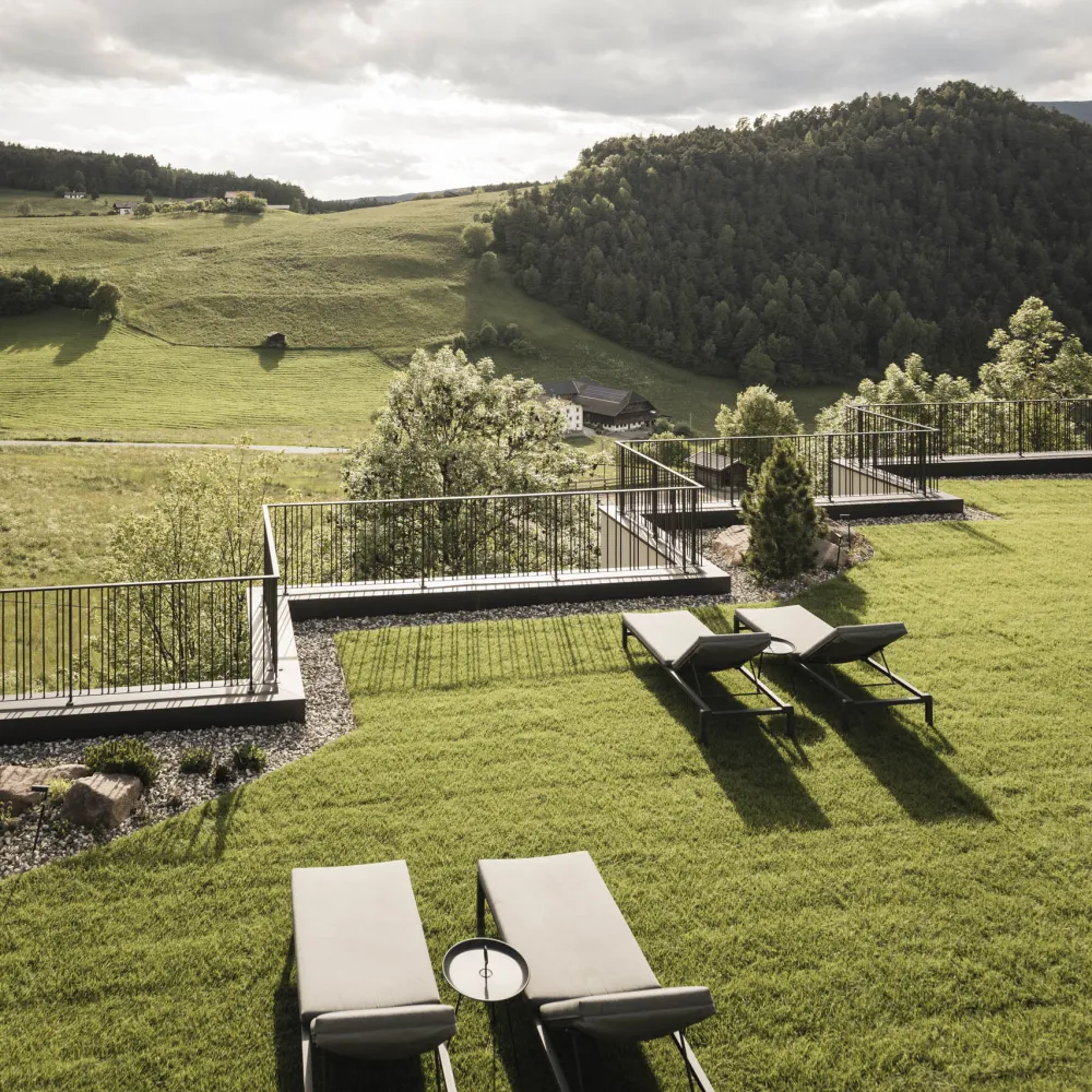 Sonnenliegen auf der Gartenterrasse des Alpenflora mit Blick auf die Seiser Alm