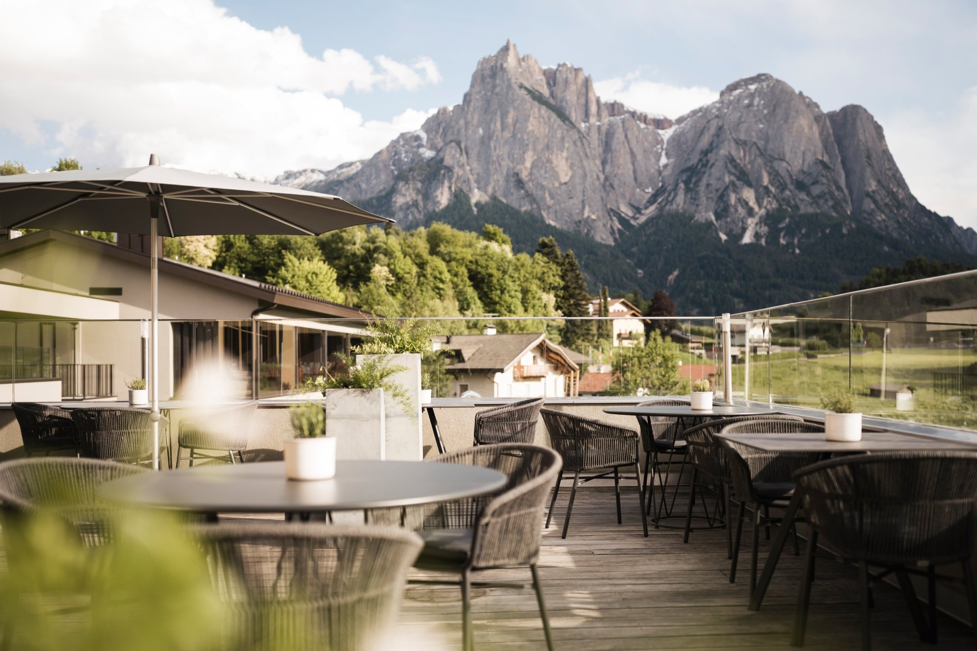Terrasse des Wellnesshotel Alpenflora mit Sitzplätzen und Blick auf die Dolomiten