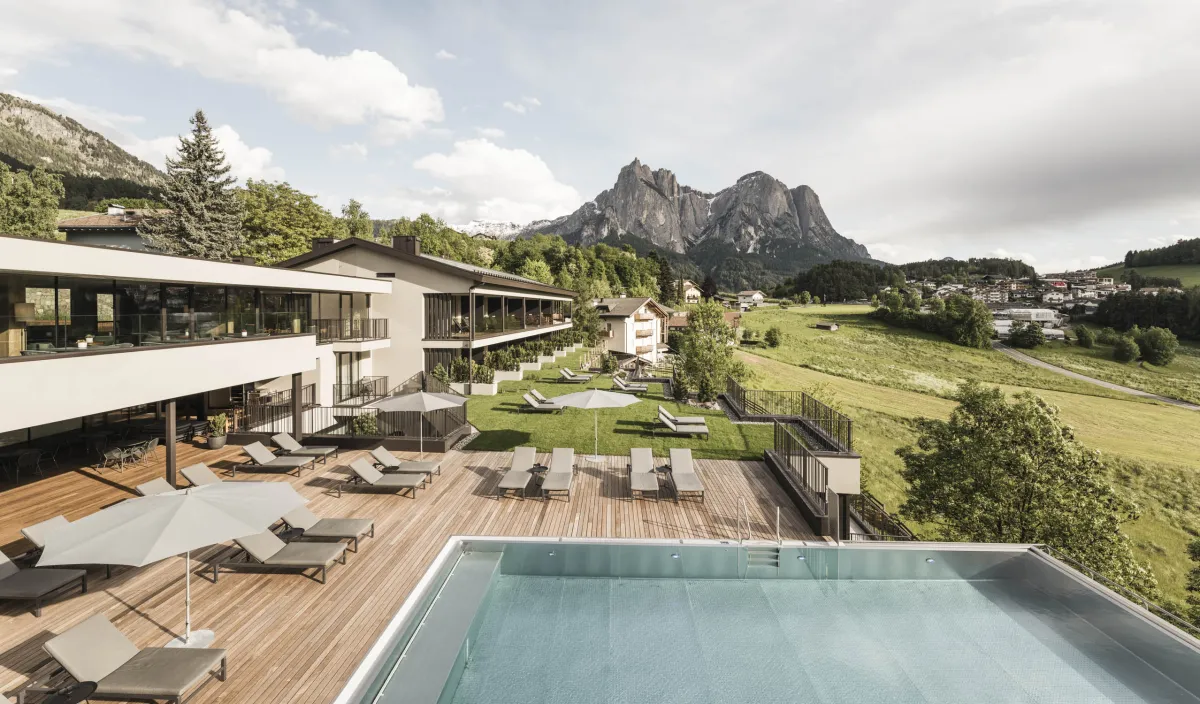 Exterior view of the Wellness Hotel Alpenflora with pool and terrace against the mountain backdrop