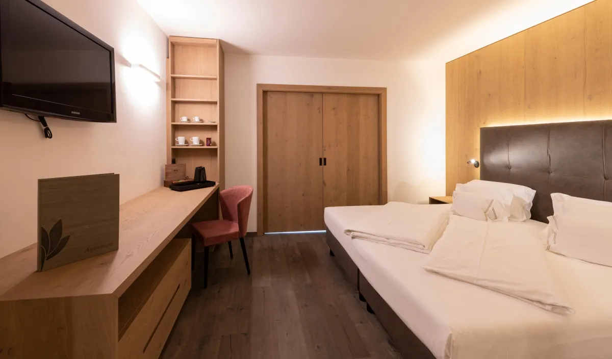 Zweites Schlafzimmer der Sun Suite mit Doppelbett, Schreibtisch, Holzschrank und Stuhl in Bordeaux.