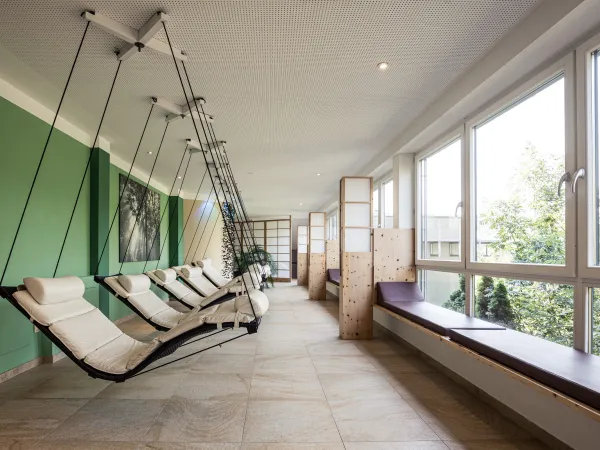 Lettini relax davanti alle vetrate nell’area benessere del Wellnesshotel Alpenflora