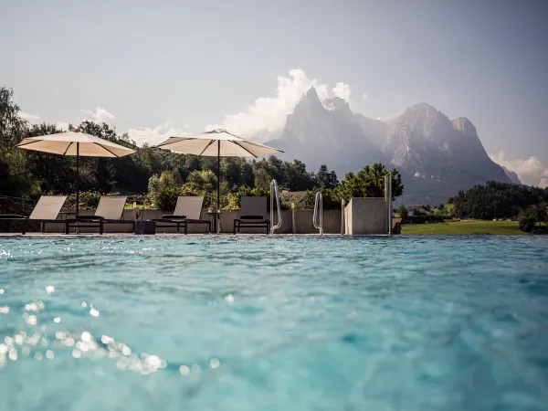Piscina esterna con ombrelloni e vista sulle Dolomiti all’Alpenflora