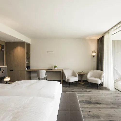 Garden Relax double room with double bed, desk, two armchairs and open access to the terrace.