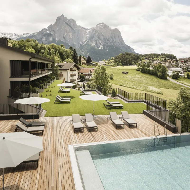 Sommeransicht des Wellnesshotels Alpenflora mit Gartenpool und Blick auf den Schlern